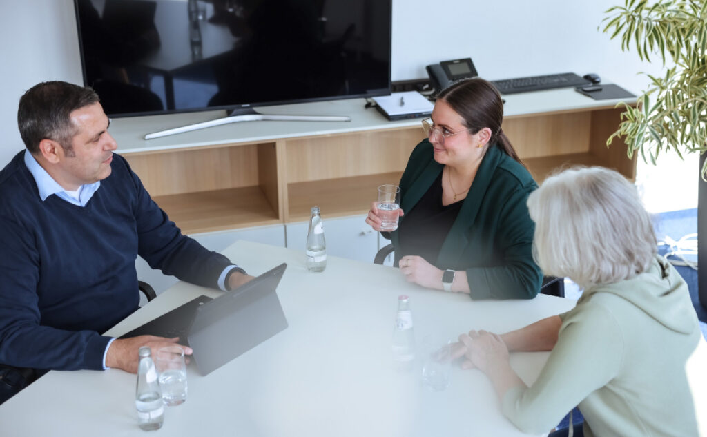 Drei Mitarbeiter:innen im Büro von Goerke und Partner besprechen digitale Prozesse am Laptop – im Vordergrund DATEV-Login und Kanzlei.land-Oberfläche.